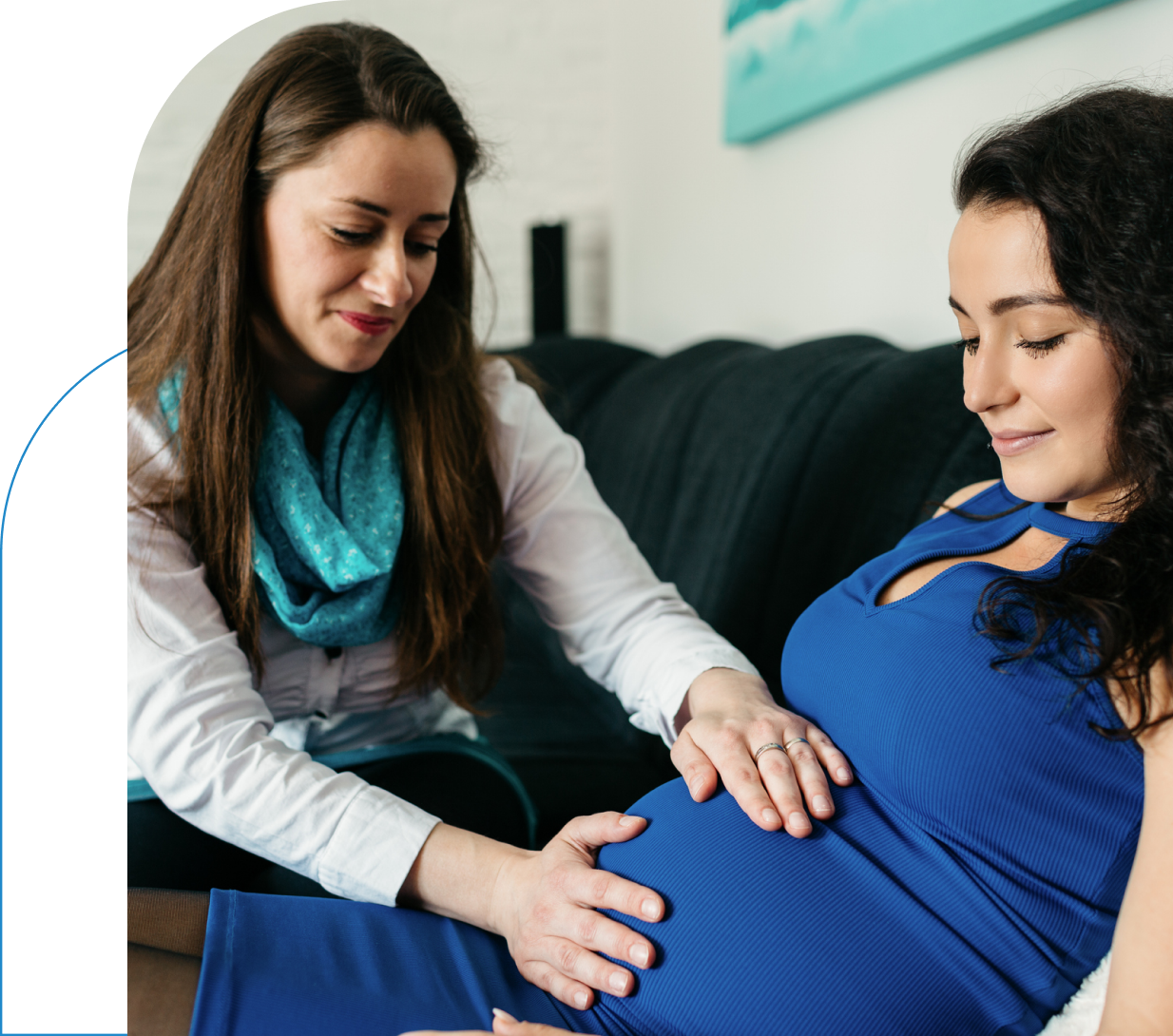 Pregnant woman with friend touching her belly.